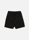 A model wears the Black Kelly Cotton Simple Short, which are shown from a front angle against a plain white background. The shorts feature an elasticated waistband with an adjustable drawstring and vertical side pockets. The fabric has a fine ribbed texture, and the garment is cut to sit just above the knee. No other accessories or clothing items are prominent in the focus of this image.