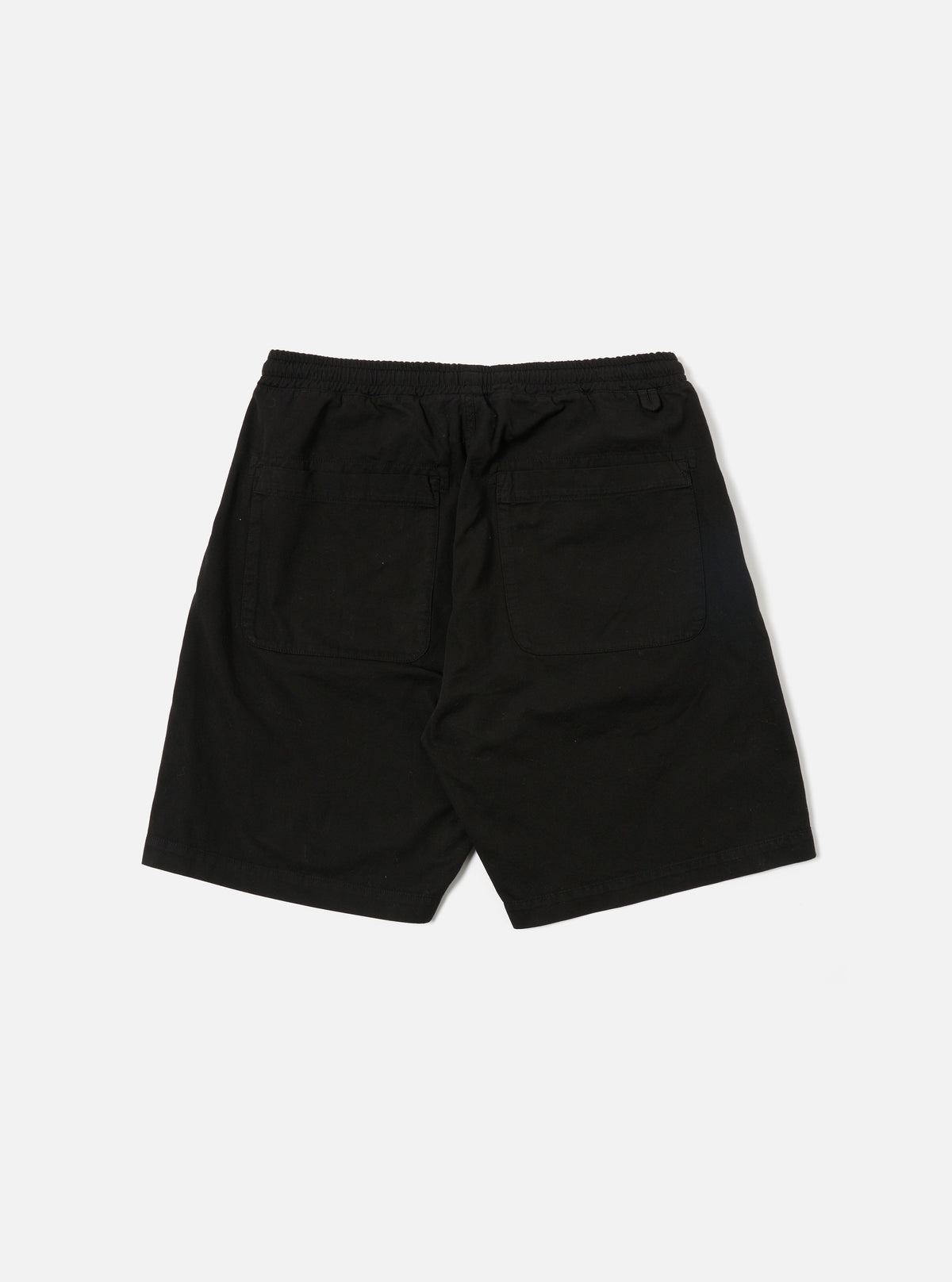 A model wears the Black Kelly Cotton Simple Short, which are shown from a front angle against a plain white background. The shorts feature an elasticated waistband with an adjustable drawstring and vertical side pockets. The fabric has a fine ribbed texture, and the garment is cut to sit just above the knee. No other accessories or clothing items are prominent in the focus of this image.