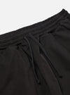 The Black Kelly Cotton Simple Short is shown from the back as a flat lay against a plain white background. The shorts feature an elasticated waistband and a single patch pocket on the right rear side. The fabric is a solid black cotton with visible stitching details.