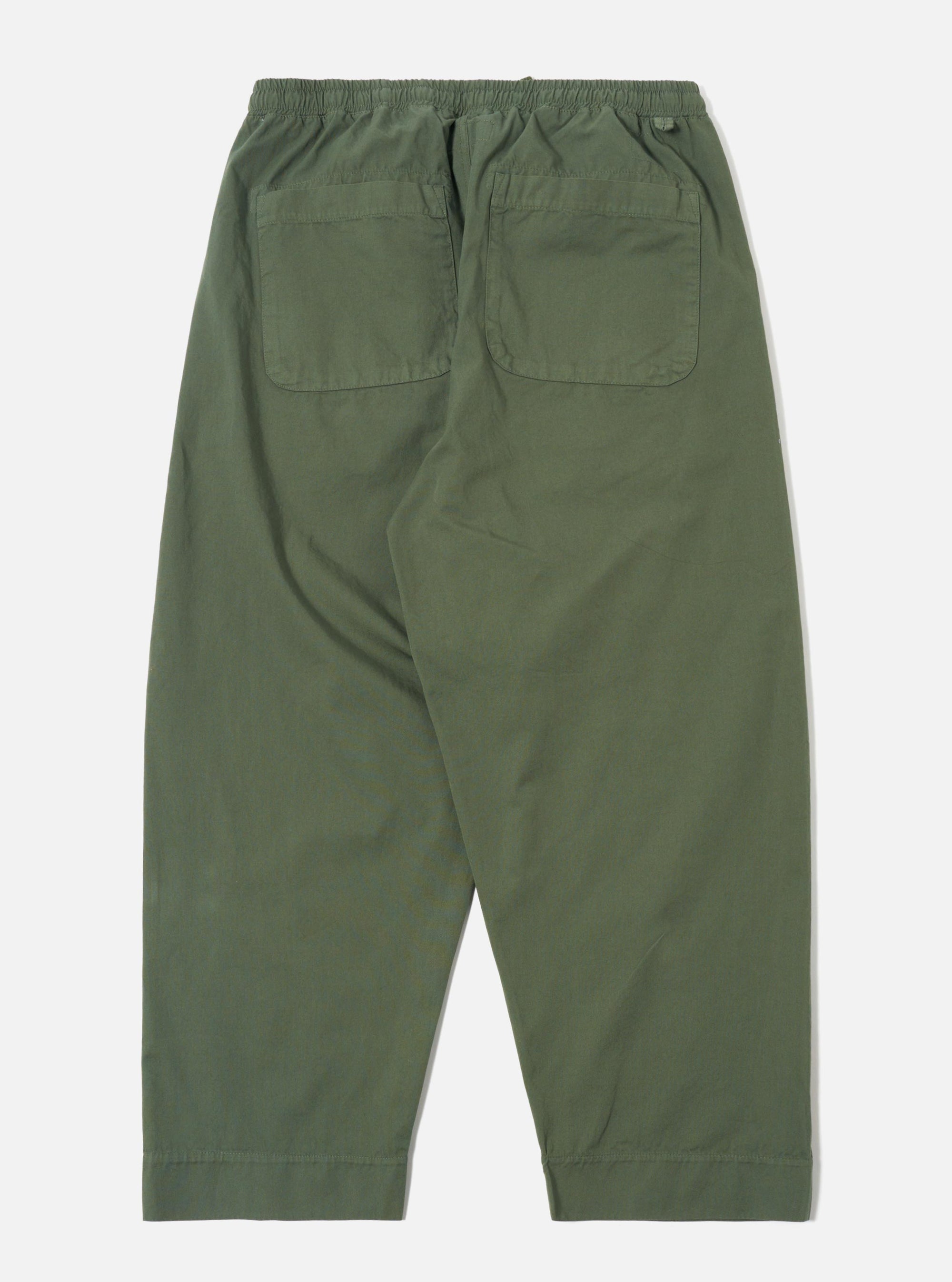 The Olive Kelly Cotton Judo Pant is shown from the back in a flat lay position against a plain white background. The trousers feature a relaxed, wide-leg fit, an elasticated waistband, and a single square patch pocket on the right rear side. The garment is made from a solid olive green cotton fabric.