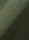 A close-up swatch of the Olive Kelly Cotton Judo Pant highlights the olive green color and the textured weave of the cotton fabric. The material fills the frame, providing a detailed view of the garment's color and construction.