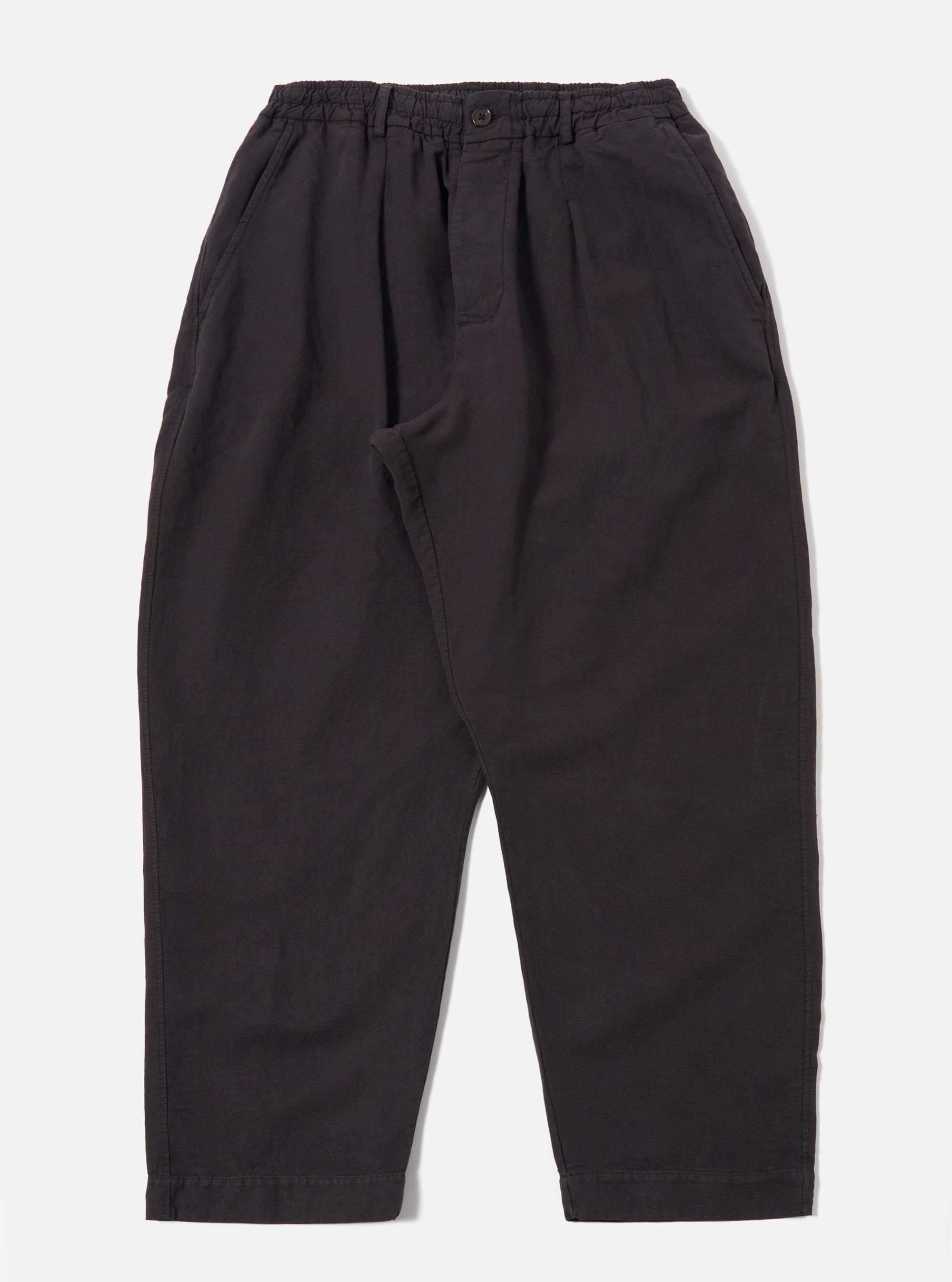 The Licorice Lyo Linen Mix Oxford Pant is shown as a flat lay against a plain white background. The trousers feature a loose, wide-leg fit, an elasticated waistband with a tonal drawstring, and two side pockets. The fabric is a dark brown, licorice-colored linen mix with a visible smooth texture.
