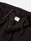The Licorice Lyo Linen Mix Oxford Pant is shown from the back as a flat lay against a plain white background. The trousers feature an elasticated waistband and two rear pockets, including one with a buttoned flap and one button-jetted pocket. The dark brown fabric has a soft, matte appearance.