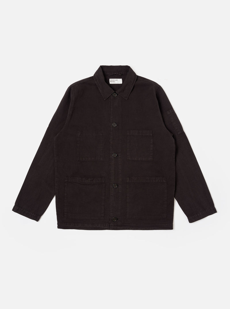The Licorice Lyo Linen Mix Coverall Jacket is shown as a flat lay against a white background. The jacket features a full collar, a button-down front, and three large square patch pockets on the front, with an additional small pen pocket located on the sleeve. The garment is made from a brown lyo-linen mix fabric and has a short, square fit with simple cuffs.
