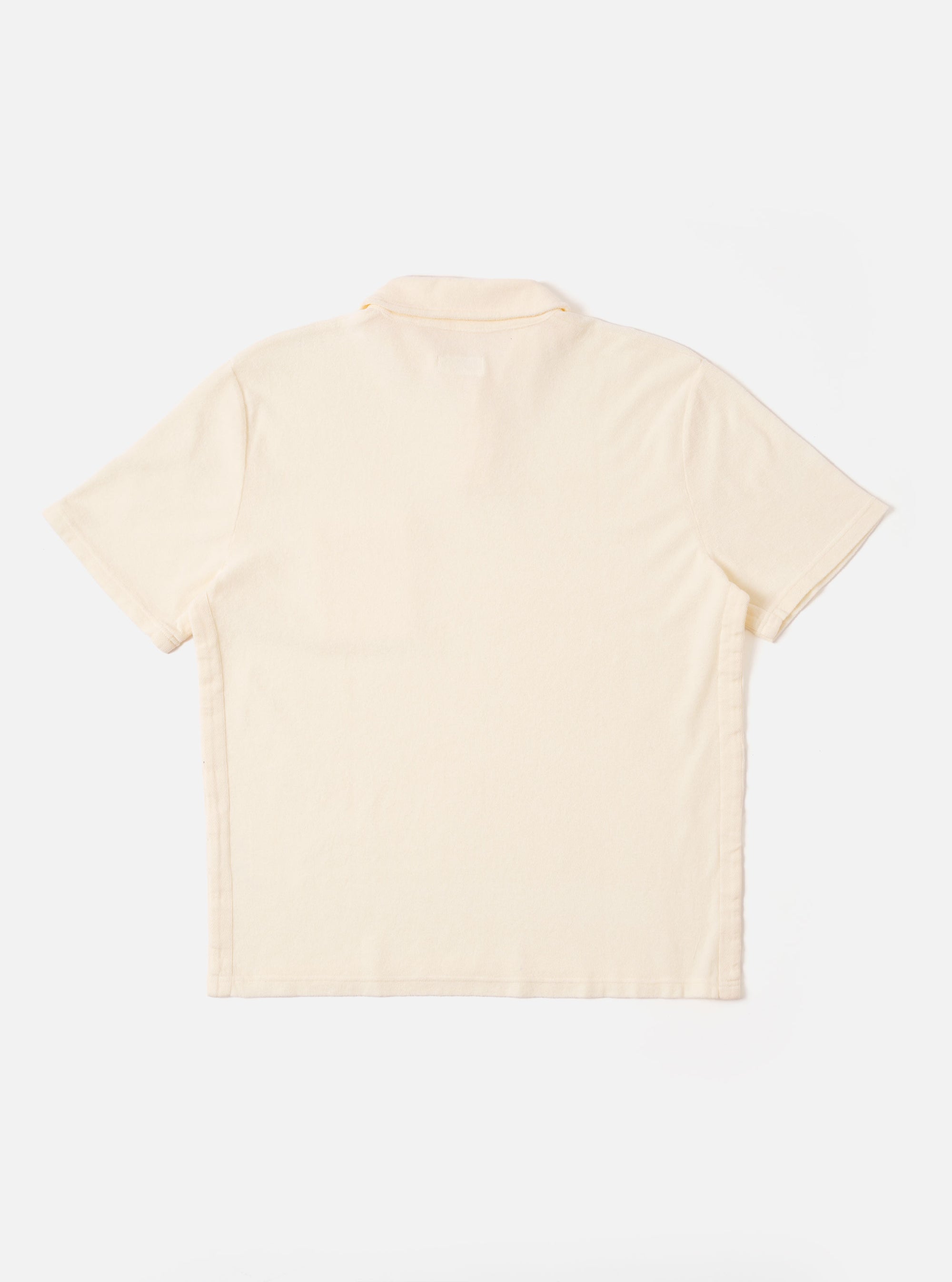 The Ecru Light Weight Terry Newlyn Polo is shown from the back as a flat lay against a plain white background. The image highlights the clean construction of the rear panel, the short sleeves, and the ribbed texture of the light weight terry fabric in a solid ecru color.