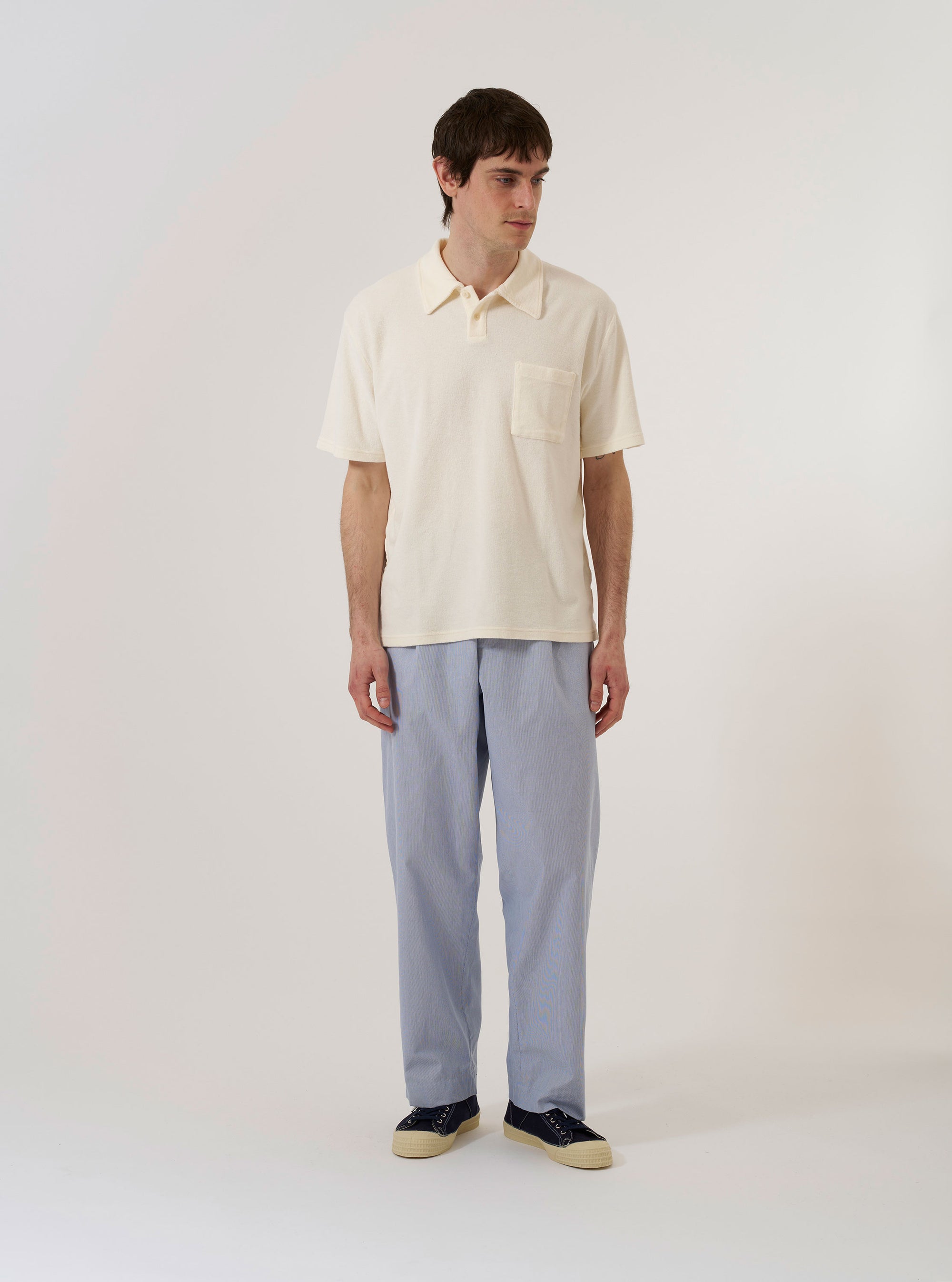 The Ecru Light Weight Terry Newlyn Polo is shown as a flat lay against a plain white background. The polo shirt features a three-button placket, a classic polo collar, and a single patch pocket on the left chest. The fabric has a soft, textured terry finish in a solid ecru color.