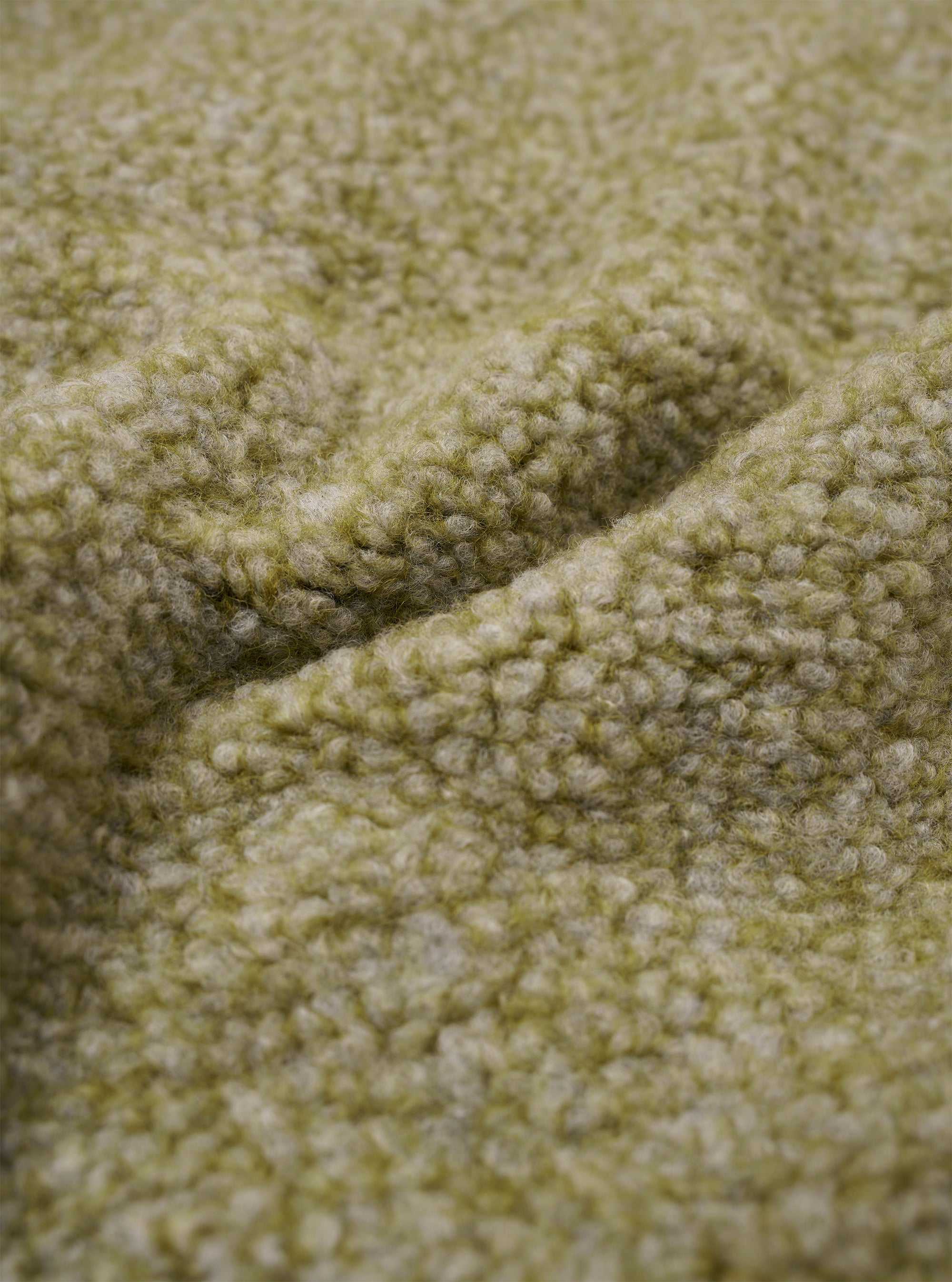 A close-up fabric swatch of the Light Olive Alvar Fleece Lancaster Jacket is displayed, highlighting the thick and curly texture of the light olive green fleece material. No background, model, or mannequin is present in the image.