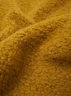 A close-up fabric swatch of the Yellow Alvar Fleece Lancaster Jacket is displayed, highlighting the thick and curly texture of the yellow fleece material. No background, model, or mannequin is present in the image.