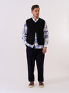 The Black Alvar Fleece Lancaster Gilet is shown as a flat lay against a plain white background. The gilet features a textured, fuzzy black fleece fabric, a rounded shawl collar, and a central button-down closure. It includes two large patch pockets at the waist and a single patch pocket on the left chest.