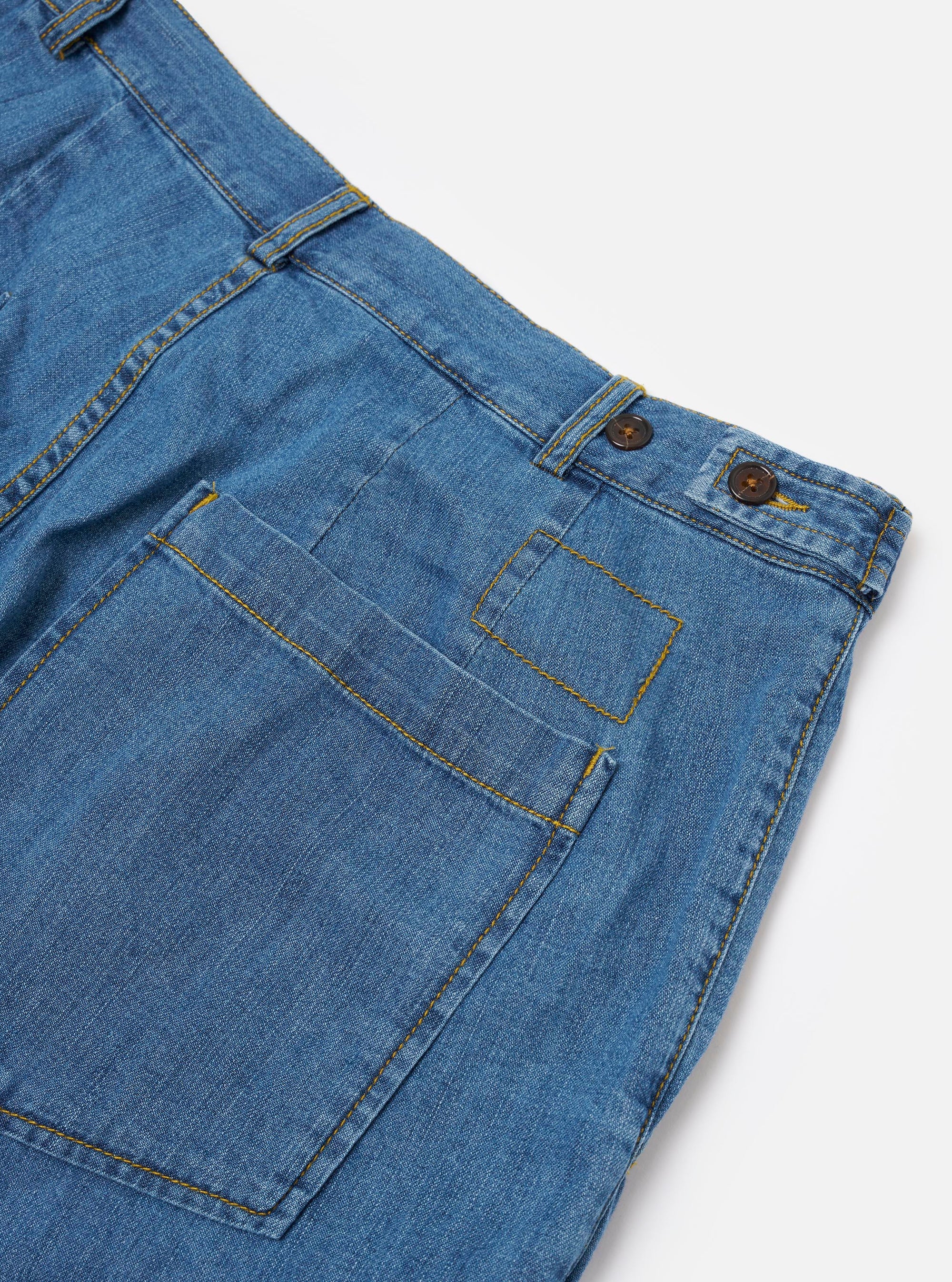 The Washed Indigo 8oz Slub Denim Dutch Pant is shown from the back as a flat lay against a plain white background. The image highlights two large rear patch pockets and the wide-leg silhouette of the trousers. The light blue denim fabric features a visible washed, slubby texture.