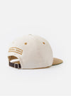 The Ecru/Sand Canvas Baseball Hat is shown as a flat lay against a white background. The 6-panel cap features a prominent wide peak in a contrasting sand color, while the crown is ecru. An adjustable strap with a metal buckle is visible at the rear.