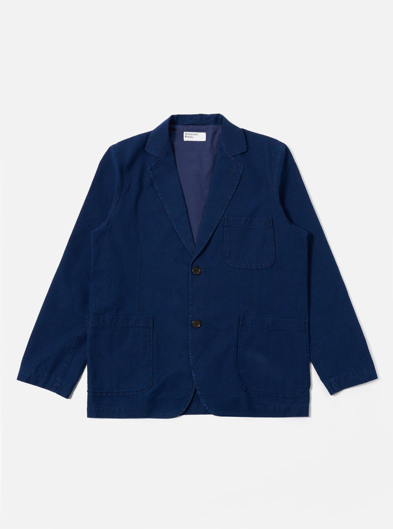 The Indigo Kimstop Two Button Jacket is shown as a flat lay against a white background. The jacket features a two-button front closure, a long and wide lapel, two lower patch pockets, and a single chest patch pocket. The indigo cotton-rich fabric has a smooth, uniform texture.