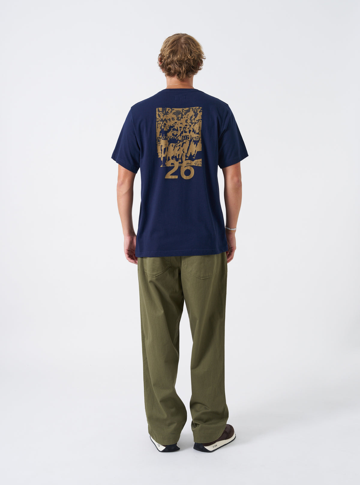 A model presents the Walsh x Universal Works Navy Single Jersey T Shirt against a plain studio background. The alternative view focuses on the relaxed fit across the chest, shoulders, tidy hemline, and deep navy colorway.
