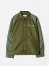Front view of the Walsh x Universal Works Olive Flight Nylon Club Coach Jacket on a plain background. Prominent features include the snap-button front, classical collar, side pockets, and durable olive green flight nylon fabric.
