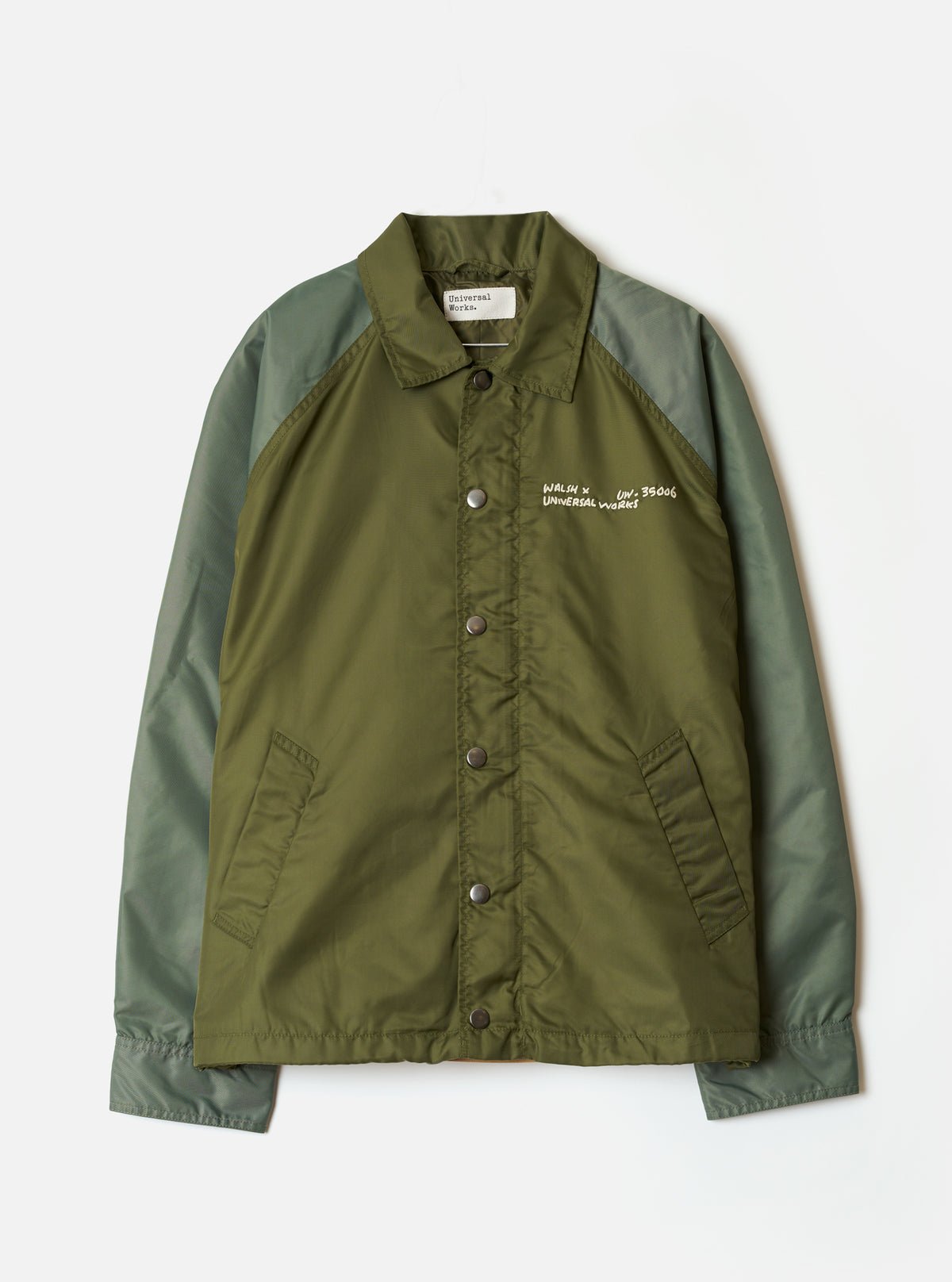 Front view of the Walsh x Universal Works Olive Flight Nylon Club Coach Jacket on a plain background. Prominent features include the snap-button front, classical collar, side pockets, and durable olive green flight nylon fabric.