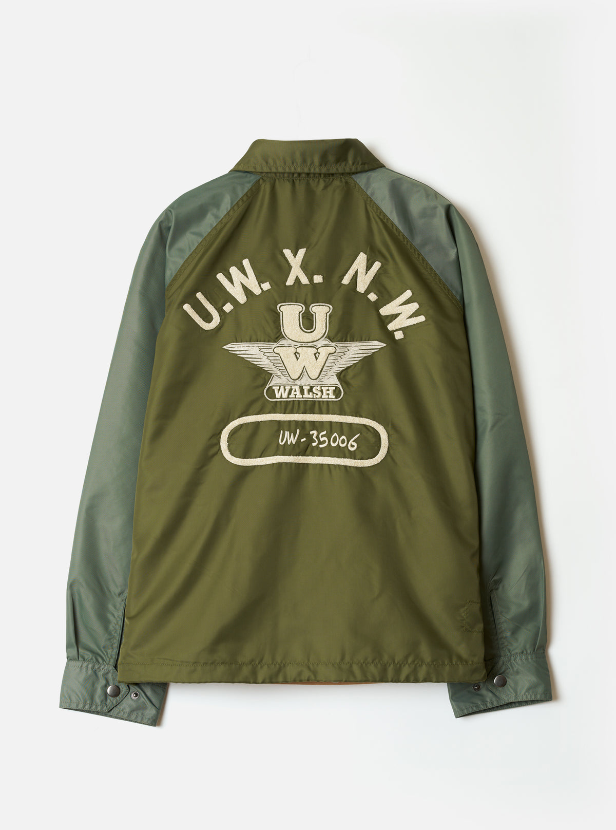Front view with snap buttons open of the Walsh x Universal Works Olive Flight Nylon Club Coach Jacket against a plain background. The shot displays the inner lining, collar shape, welt pockets, and smooth olive green nylon material.