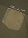 Close-up front view of the Walsh x Universal Works Olive Brushback Sweat Panelled Loose Sweatshirt on a neutral background. The shot focuses on the intricate seam paneling, crewneck collar, and durable olive brushback cotton fleece.