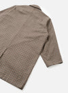 An angled product shot of the Taupe Lester Dogtooth Stan Coat set against a clean neutral background. Prominent features include the structured overcoat silhouette, woven dogtooth check pattern, and deep side pockets.