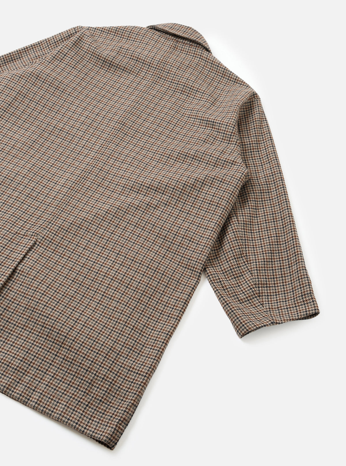 An angled product shot of the Taupe Lester Dogtooth Stan Coat set against a clean neutral background. Prominent features include the structured overcoat silhouette, woven dogtooth check pattern, and deep side pockets.