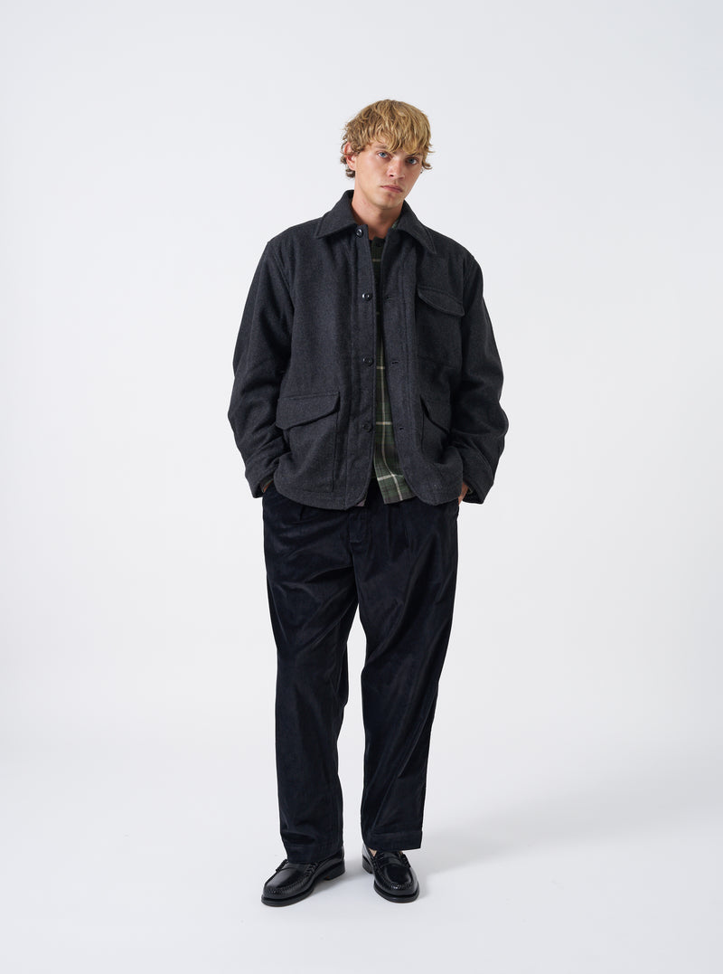 A male model poses against a plain studio background wearing the Grey Marl Mowbray Heavy Duty Jacket. The full front view highlights the textured grey wool-blend fabric, button closure, chest pocket, and collar.