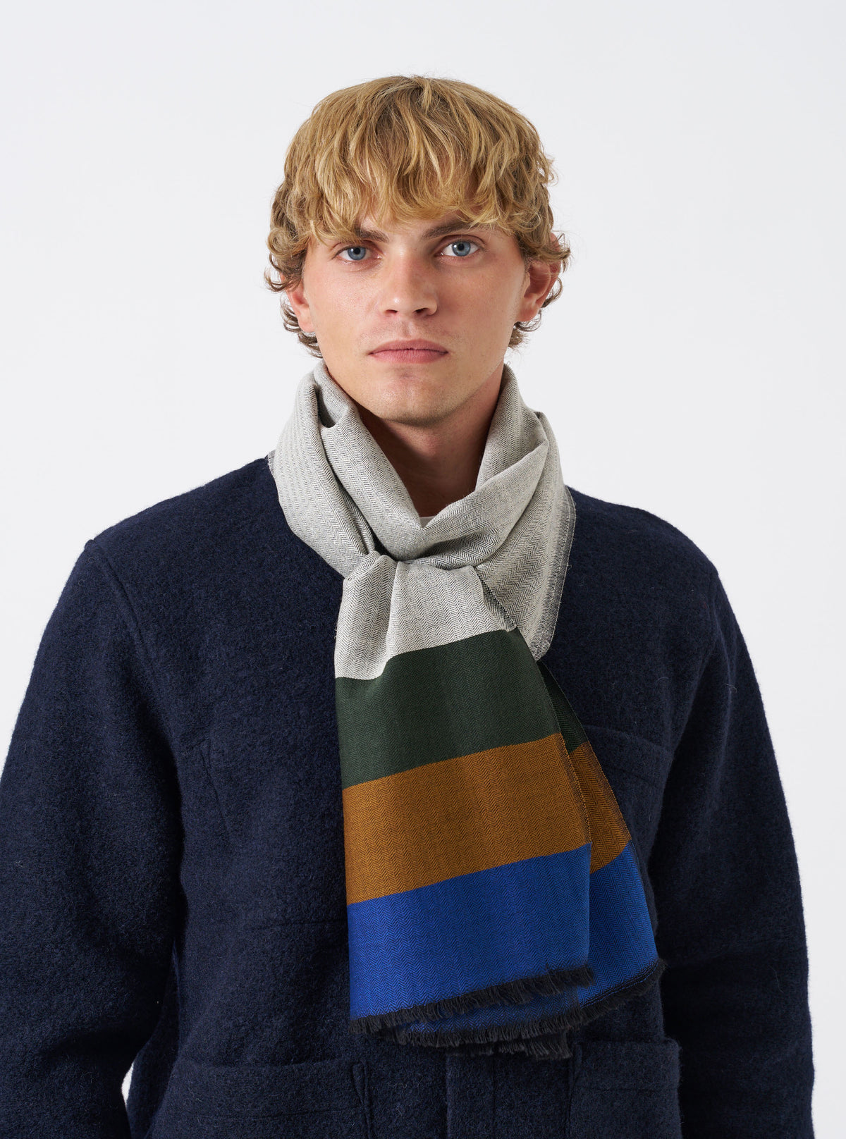 A full product image of the Grey Reversible Wool Himalayan Scarf set against a plain light backdrop. The shot emphasizes the subtle grey tones, frayed edge details, and lightweight reversible wool weave.