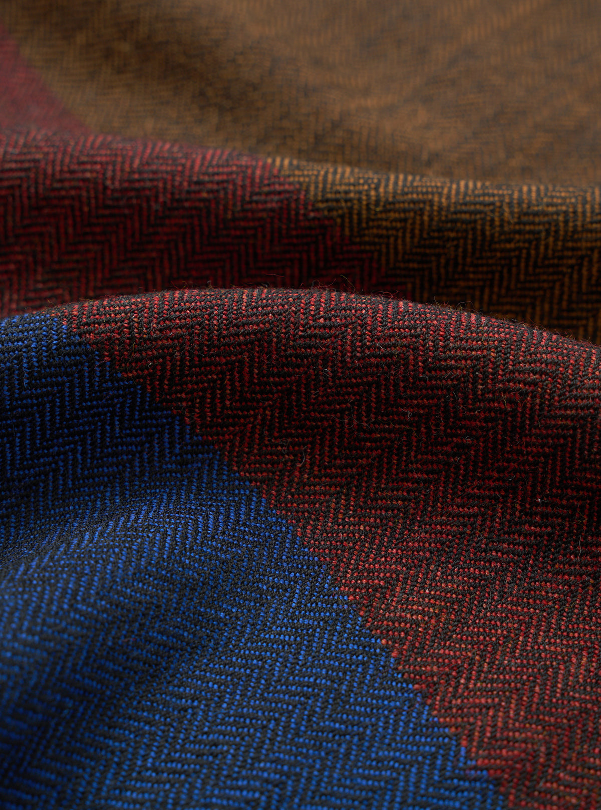 A close-up fabric swatch shot of the Brown Reversible Wool Himalayan Scarf on a plain background. The image focuses on the fine detail of the brown wool weave, tactile surface finish, and rich thread structure.
