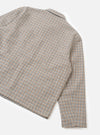Flat lay of the taupe Lester Dogtooth Franck Jacket on a white studio backdrop, showing the upper body and one sleeve. The fabric features a multicolour dogtooth weave in taupe, tan, grey and navy. A spread collar is visible at the top. The unfinished cuff is shown at the sleeve hem.