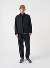 A model wears the Black Brushed Moleskin Franck Jacket against a light studio background. The shot highlights the dark black brushed moleskin fabric, structured tailoring, notched lapels, and front button closure of the jacket.