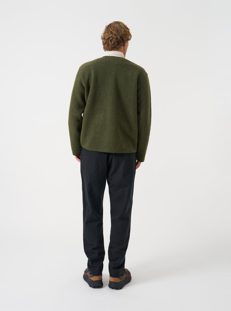 A model wearing the Universal Works Black Brushed Moleskin Military Chino, shown from the front against a plain background. The black cotton trousers feature a slim straight fit, mid-rise waist, button fly, and slanted side pockets.