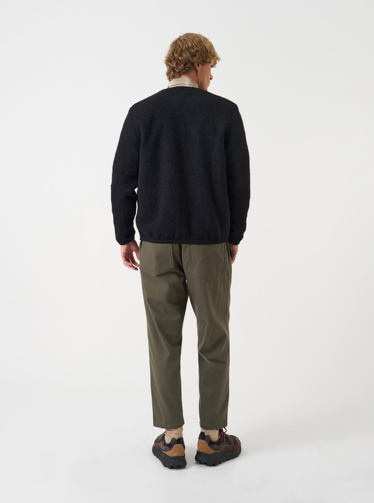 A back view of a model wearing the Universal Works Olive Brushed Moleskin Hi Water Trouser against a plain studio background. The photo highlights the high-water cropped hem, olive brushed cotton fabric, and rear patch pocket details.