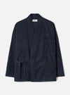 Navy wool mix Kyoto work jacket in a tonal glen plaid pattern, flat lay on a light grey backdrop. The open-front jacket features a shawl collar, two large patch pockets at the hip, a chest patch pocket, and a self-tie belt at the waist. Long sleeves with plain cuffs. Universal Works woven label at the neckline.