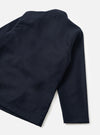 Back view of a navy wool mix Kyoto work jacket laid flat on a white studio surface. The fabric features a tonal check pattern in dark navy. Visible details include a stand collar, a single sleeve, and a clean straight hem. The check weave has a subtle texture throughout.