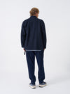 A back view of a model wearing the Navy Bob Wool Mix Kyoto Work Jacket. The image showcases the soft navy wool-blend texture, relaxed shoulders, and minimal seam construction set against a plain neutral backdrop.