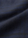 Close-up of the navy wool mix fabric used in the Kyoto Work Jacket. The brushed, softly felted surface shows fine individual fibres and a subtle dark mélange tone. Gentle folds across the cloth highlight its weight and texture.