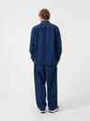 A rear view of a model wearing the Indigo Contrast Stitch Work Denim Fatigue Shirt. The image highlights the dark blue denim construction, contrast seam details, and relaxed fit set against a plain neutral background.