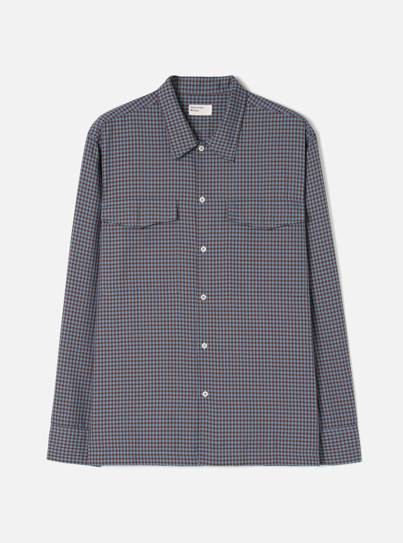 A product shot of the Universal Works Blue/Brown Parker Check Attendant Shirt laid flat against a plain background. The long-sleeve shirt features a blue and brown check pattern, flat collar, button front, and dual chest flap pockets.