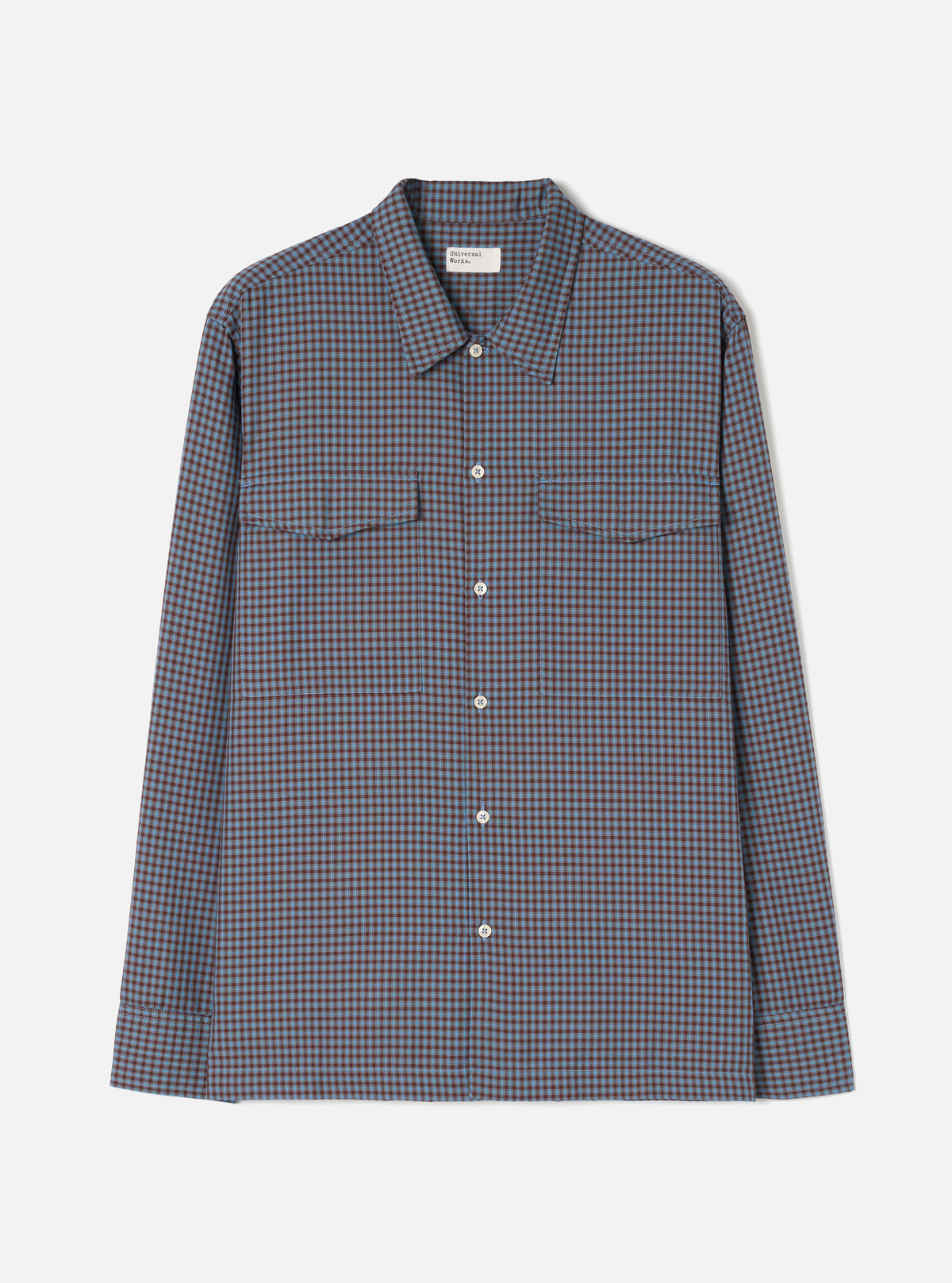 A product shot of the Universal Works Blue/Brown Parker Check Attendant Shirt laid flat against a plain background. The long-sleeve shirt features a blue and brown check pattern, flat collar, button front, and dual chest flap pockets.
