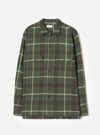 A product image of the Universal Works Olive Washed Check L/S Utility Shirt displayed on a plain background. The shirt features an olive green washed check pattern, flat collar, front button placket, and two buttoned flap chest pockets.