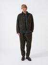 A model wearing the Olive Flock Chambray Warmus Jacket captured from the front against a plain background. The olive green cotton jacket features a neat collar, button-down front, and practical front patch pockets.