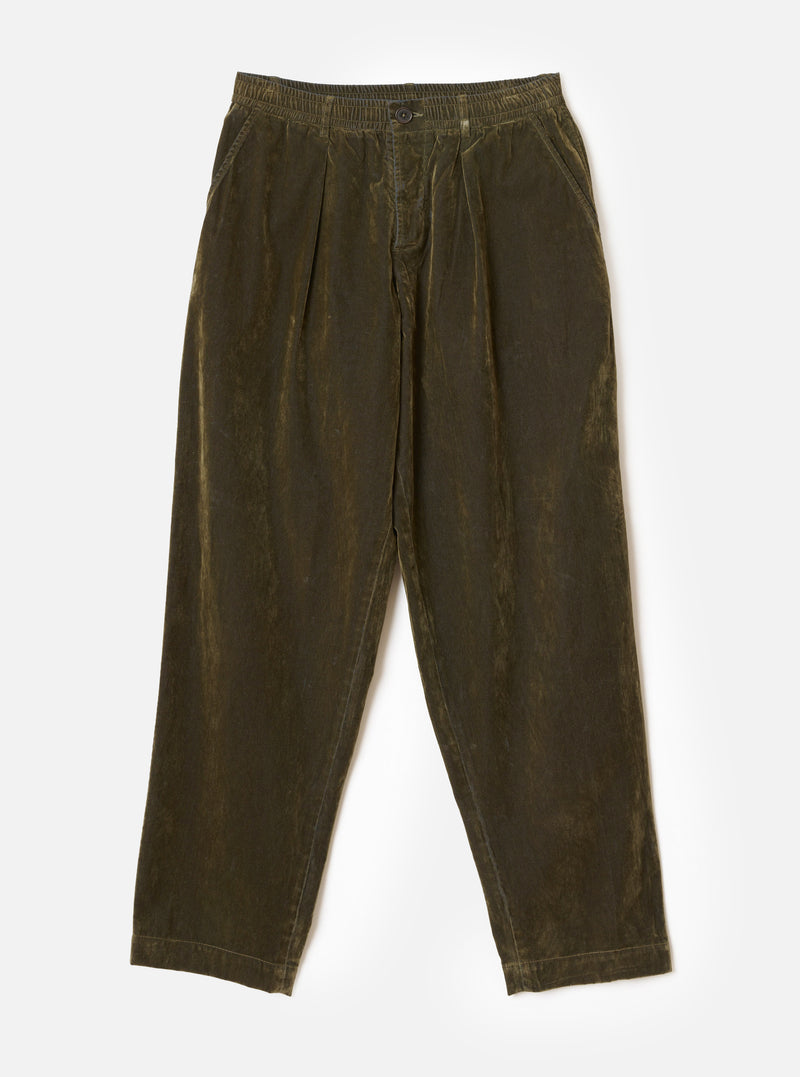 Front view of the Universal Works Olive Flock Chambray Pleated Track Pant laid flat against a plain backdrop. Highlights the olive green cotton fabric, elasticated drawstring waistband, side pockets, and relaxed pleated front design.