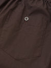 Back view of the Universal Works Brown Broadcloth Boxer Shorts against a neutral studio background. Highlights the clean rear paneling, comfortable elastic waistband, and warm brown cotton material.