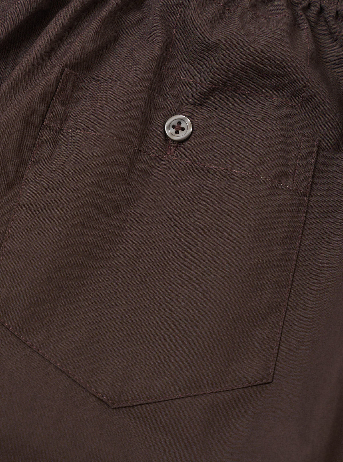 Back view of the Universal Works Brown Broadcloth Boxer Shorts against a neutral studio background. Highlights the clean rear paneling, comfortable elastic waistband, and warm brown cotton material.