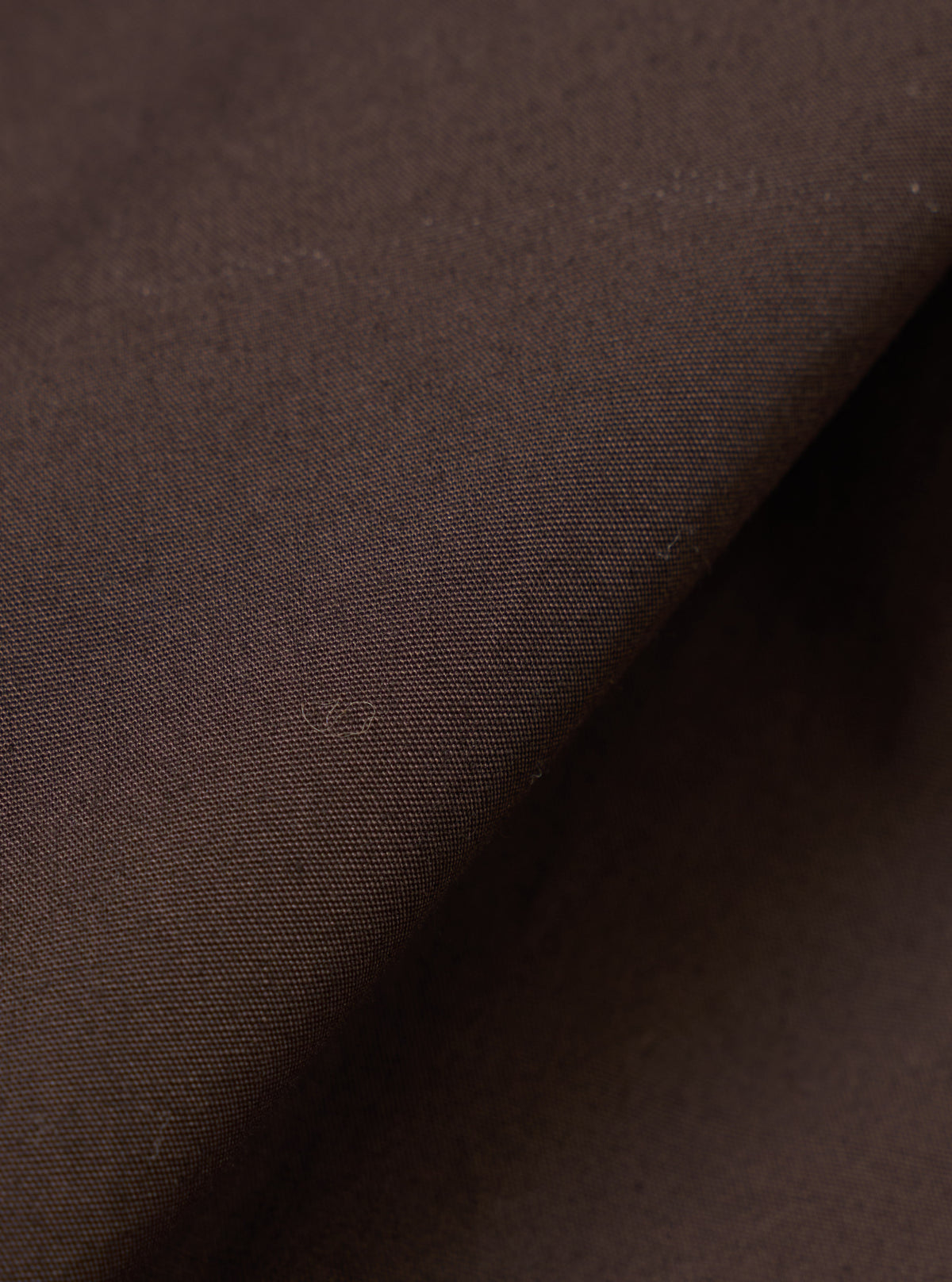 Detailed fabric swatch of the Brown Broadcloth Boxer Shorts by Universal Works. Showcases the soft cotton broadcloth weave and rich brown tone against a plain backdrop for clear texture detail.