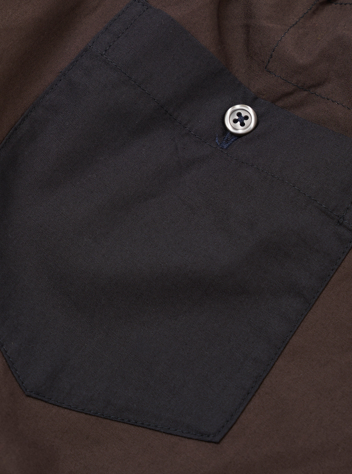 Close-up view of the Universal Works Mix Broadcloth Boxer Shorts set against a plain backdrop. Displays the contrasting cotton broadcloth panels, neat stitching details, and elastic waistband construction.