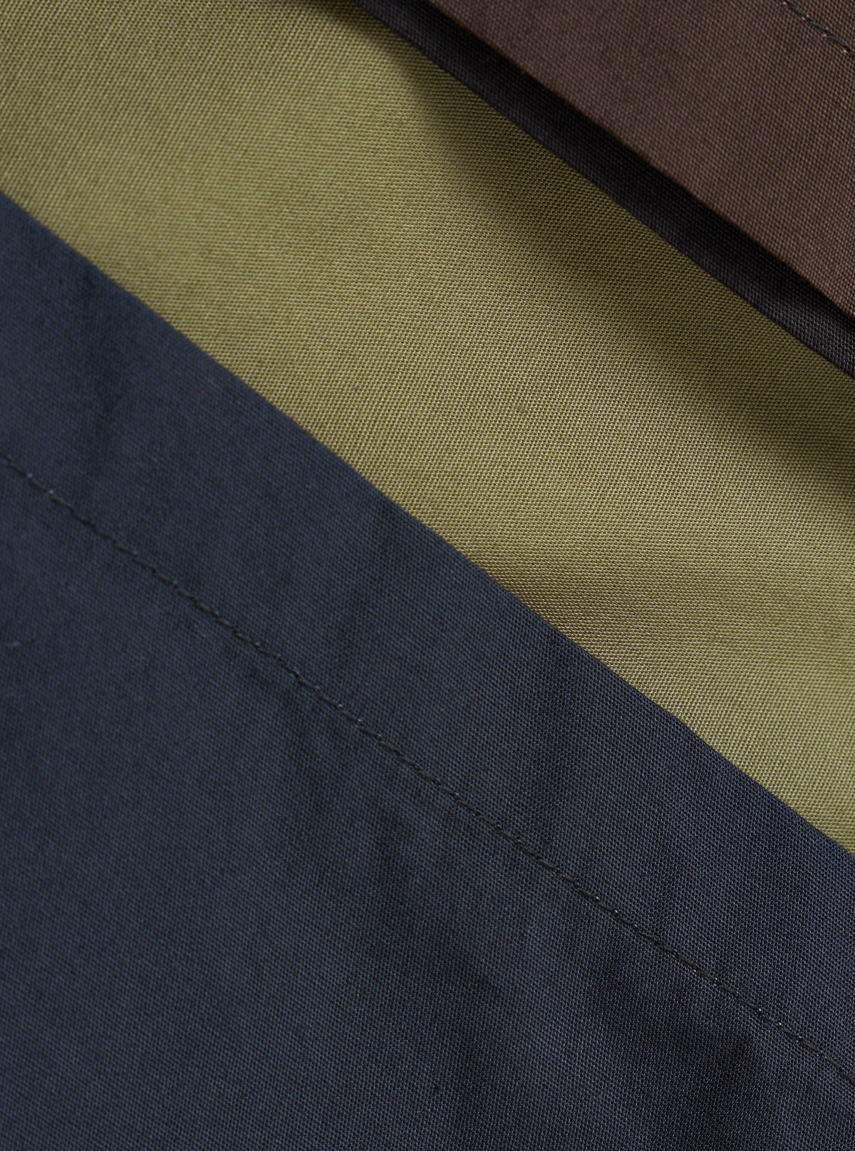 A swatch image showing the multi-colored broadcloth fabric of the Mix Broadcloth Boxer Shorts by Universal Works. Highlights the varied patterned cotton panels set against a plain backdrop.