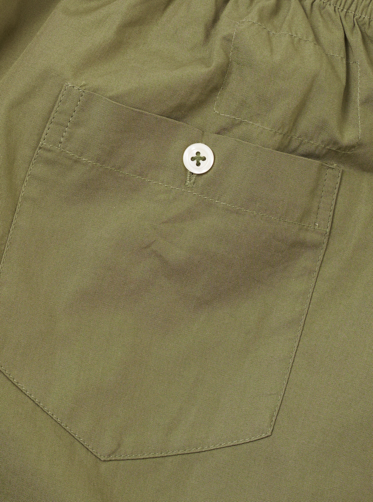 Rear view of the Universal Works Olive Broadcloth Boxer Shorts set against a plain white background, featuring a single small rear patch pocket, elasticated waist, and clean tonal stitching.