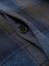 Interior detail shot of the Universal Works Navy/Brown Berlin Wool Check Account Coat against a plain backdrop, displaying the inner lining, internal zip pocket, and woven brand label.