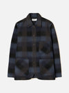 Front view of the Universal Works Navy/Brown Berlin Wool Check OG Bakers Chore Jacket against a plain backdrop. The jacket features a navy and brown check pattern, front button closure, and angled patch pockets.