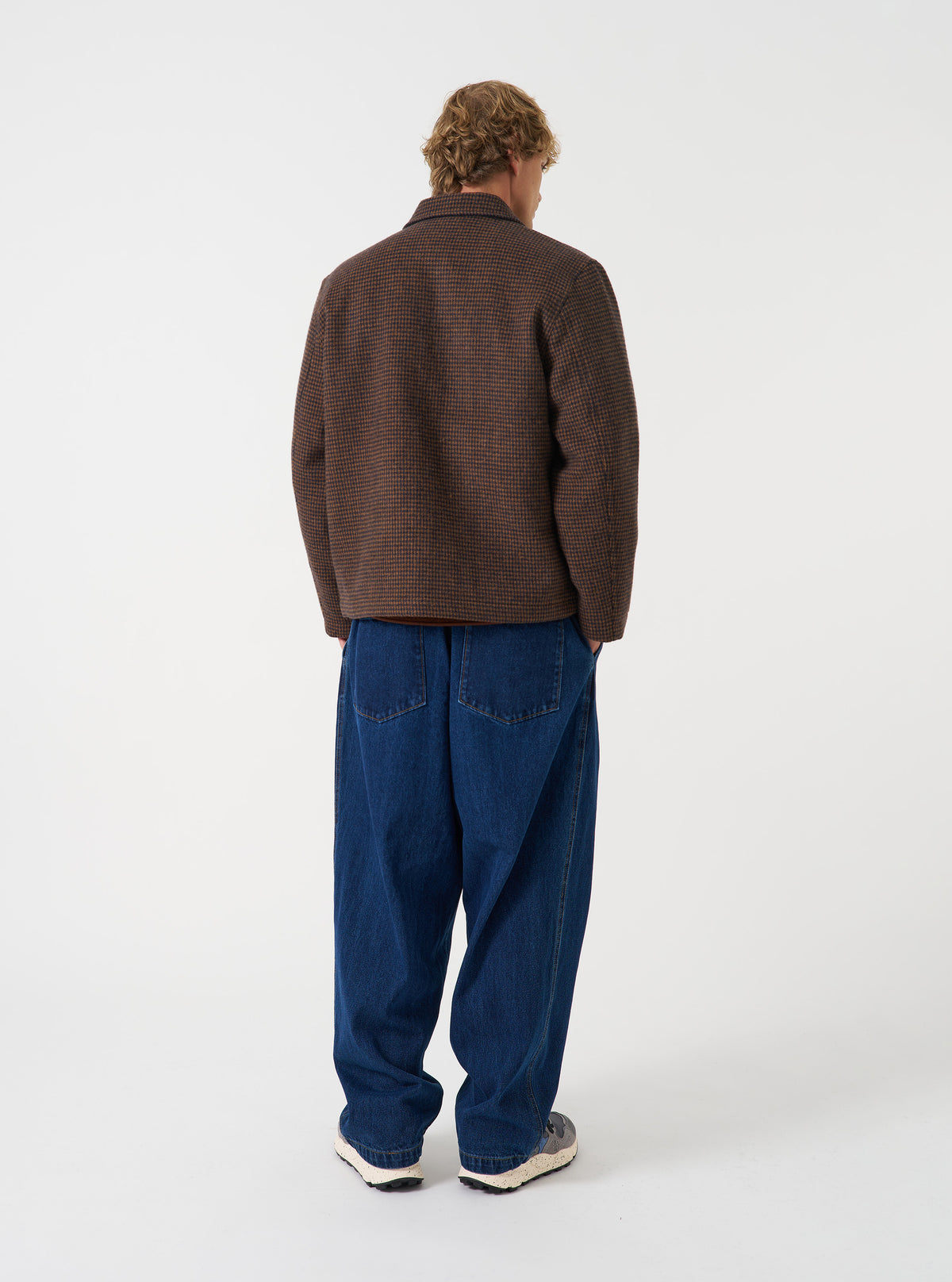 A back view of a model wearing the Navy/Brown Wool Tweed Mix Franck Jacket. The image showcases the fit across the shoulders and upper back, highlighting the clean tailoring and rich textured brown and navy tweed pattern.