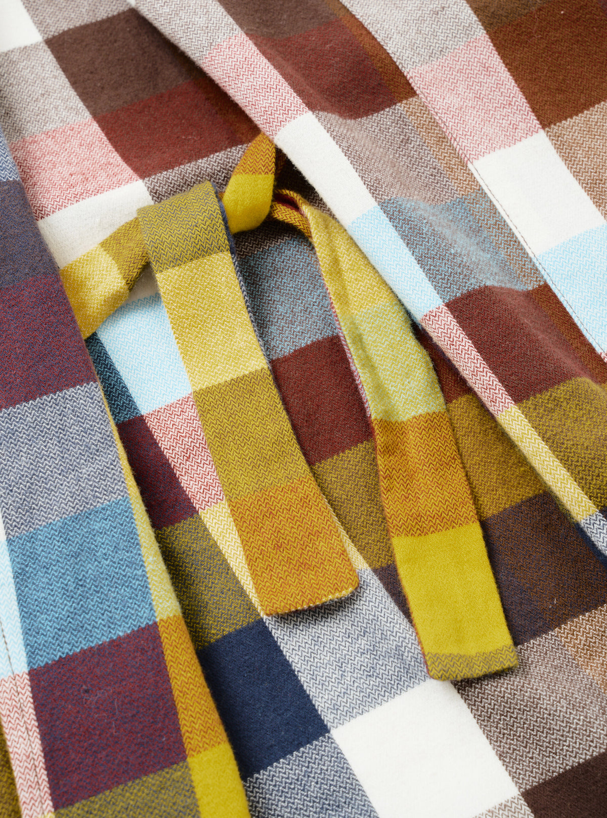 A close-up detail shot of the Multi Check Evans Check Short Dressing Gown on a white background. The image showcases the soft cotton weave, lapel stitching, and contrasting blue, red, and neutral tones in the check pattern.